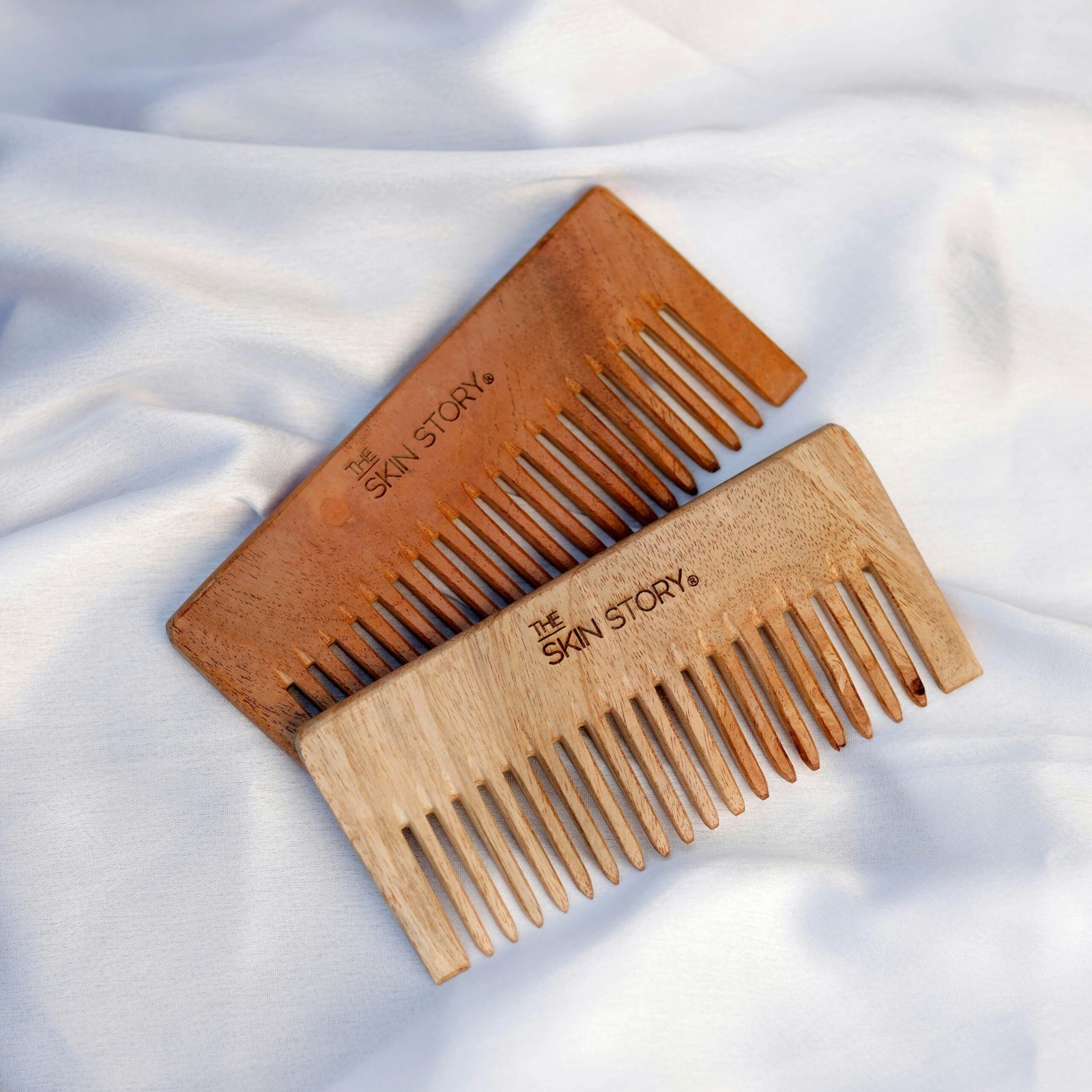 a couple of wooden combs sitting on top of a white sheet